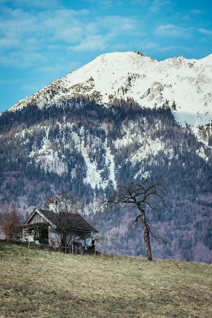 Vieille maison sur une colline montagnes enneigées en arrière-plan