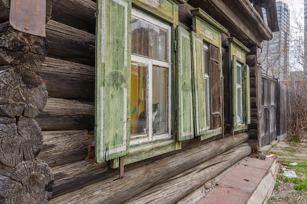 Une vieille maison en rondins avec des fenêtres.