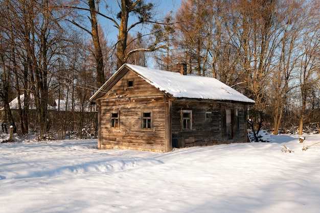 Une vieille maison rurale en bois en hiver