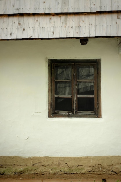 Vieille maison ukrainienne en bois avec murs d'argile et toit de paille dans le jardin d'été