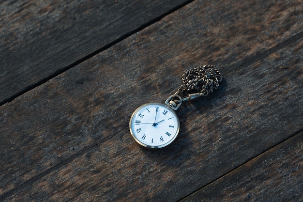 Vieille montre de poche sur fond de bois close up