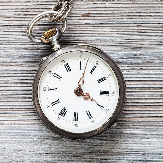 Vieille montre de poche sur table en bois gris