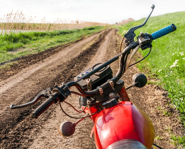 Vieille moto classique sur un chemin de terre