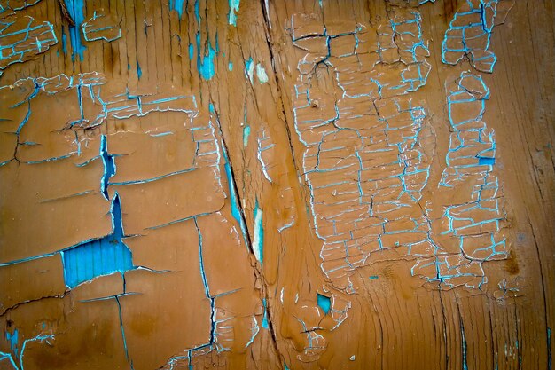 Vieille peinture brune et bleue fissurée sur des planches de bois