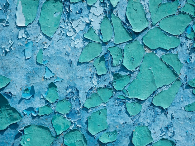 La vieille peinture écaillée patinée est bleue sur le mur. gros plan, arrière-plan, texture
