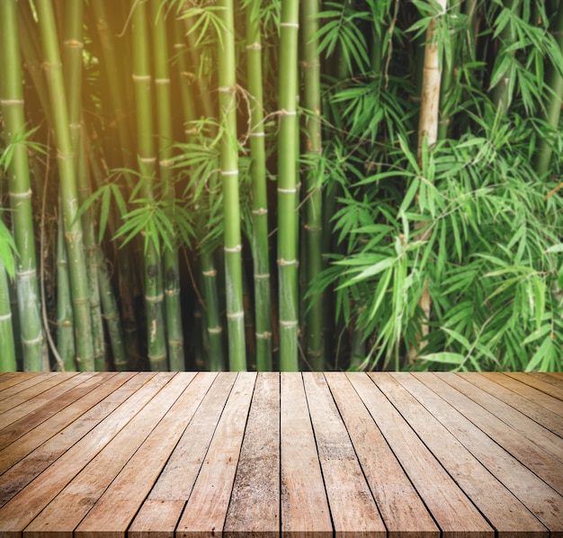 Vieille planche de bois avec fond naturel abstrait de forêt de bambou floue pour l'affichage du produit