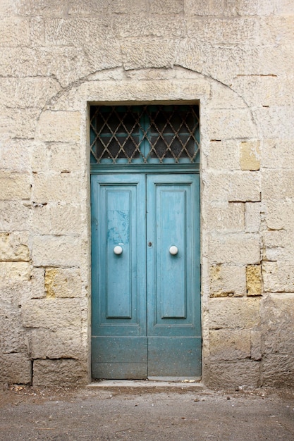 Vieille porte en bois bleu maltais typique sur le mur de calcaire de Malte Concept d'architecture vintage traditionnelle maltaise de vue sur la rue