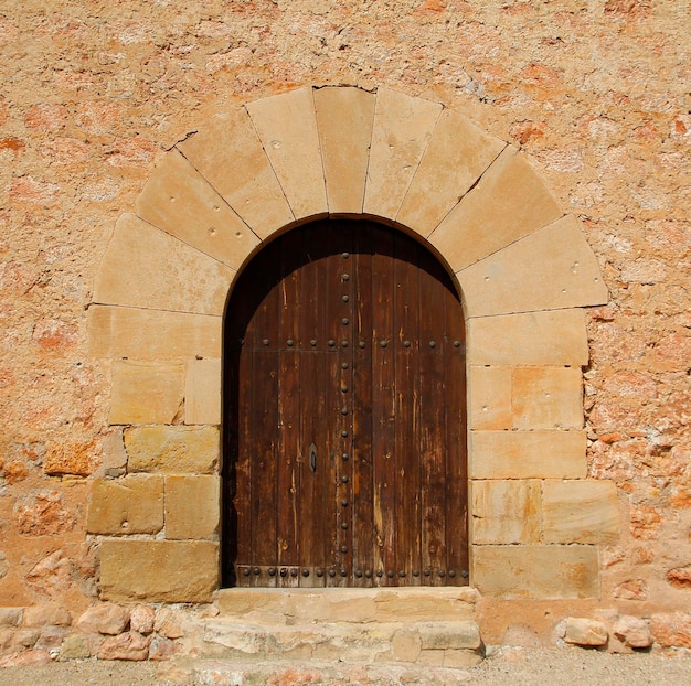 Vieille porte en bois dans une façade en pierre