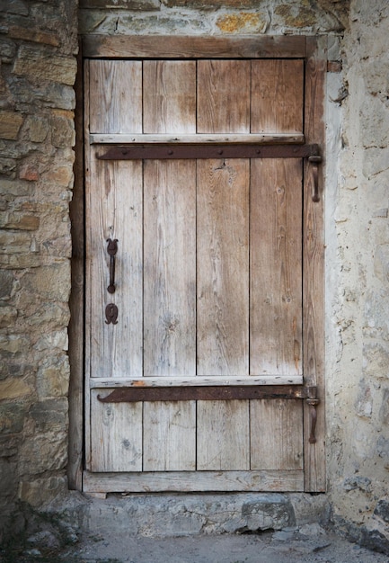 Vieille porte en bois dans un mur de pierre