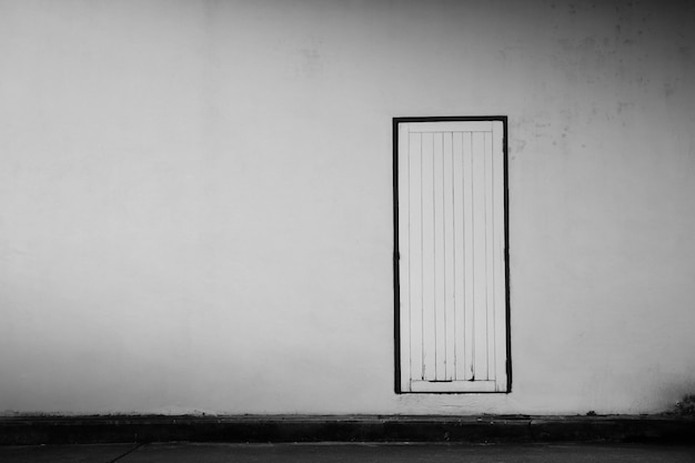 Vieille porte en bois du bâtiment en béton - monochrome