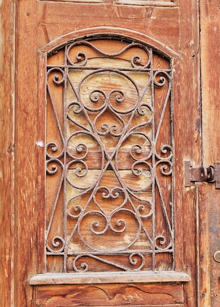 Vieille porte en bois avec grille vintage en métal