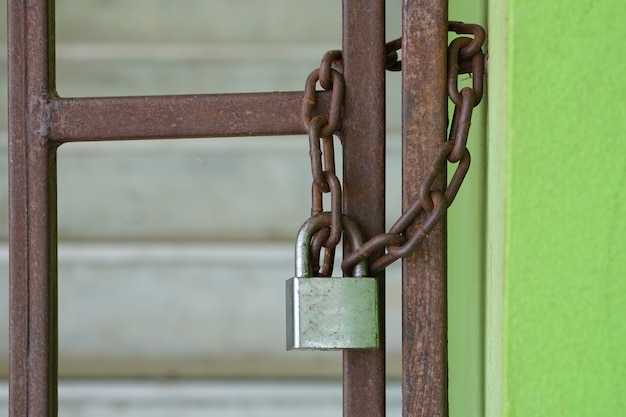 Photo vieille porte en fer rouillée, fermée par une salle d'exposition. avec un cadenas qui ne peut pas être ouvert