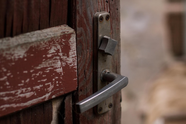 Vieille porte rouge en bois avec une poignée en métal