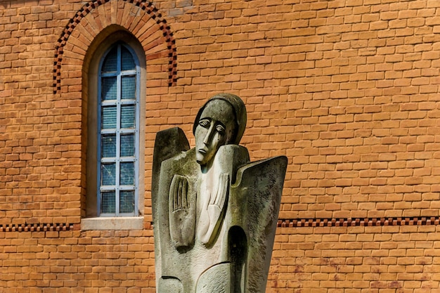 Une vieille statue religieuse de femme qui pleure sur le fond de la façade en brique du bâtiment o
