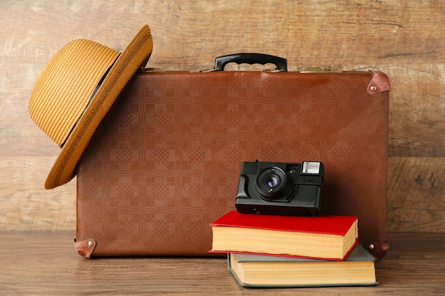 Photo vieille valise et livres avec appareil photo sur mur marron