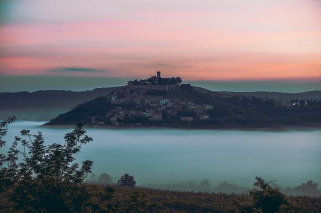 Vieille ville au sommet de la colline avec des nuages de château en dessous