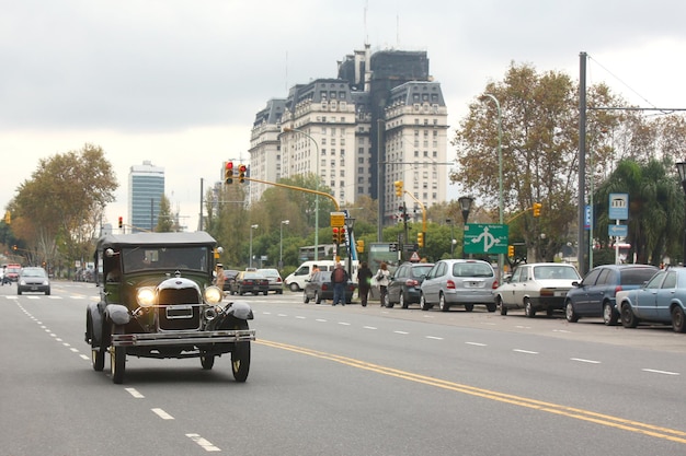 Photo vieille voiture descendant la rue