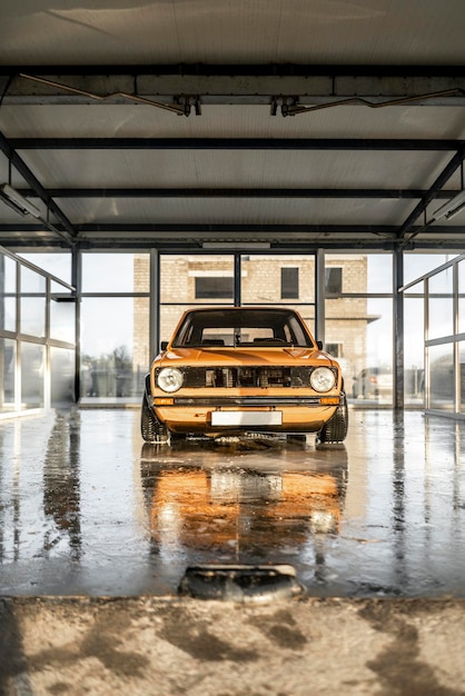 La vieille voiture orange vintage dans la boîte à laver