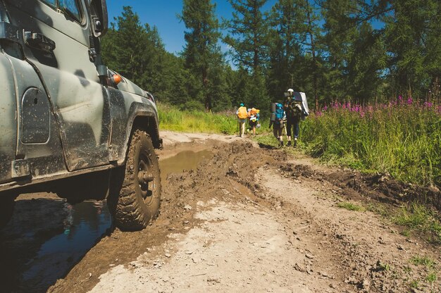 Une vieille voiture tout-terrain russe se prépare à déplacer l'obstacle sous la forme de grandes flaques boueuses sur la route infranchissable Car ATV pour les touristes en terrain difficile les passagers ont laissé la voiture coincée dans la boue