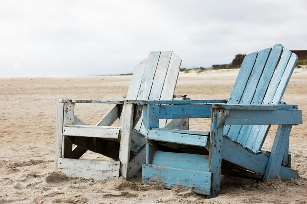 De vieilles chaises en bois vides sur la plage