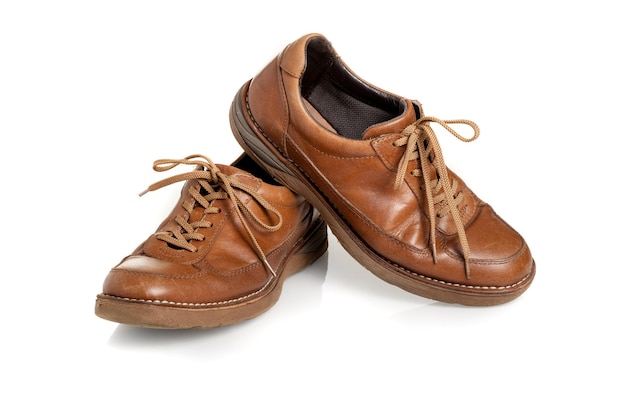 Vieilles chaussures en cuir marron pour hommes sur fond blanc