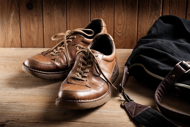 Vieilles chaussures en cuir marron pour hommes sur fond de bois