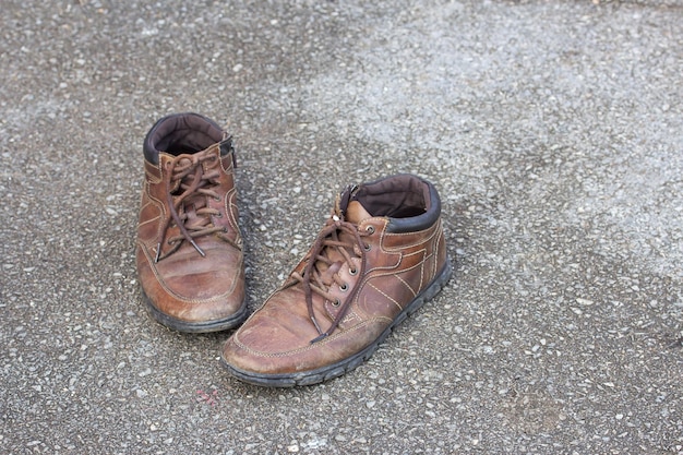 Vieilles chaussures en cuir marron sur le sol