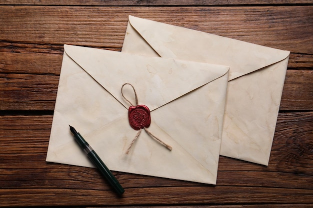 Vieilles enveloppes à lettres et stylo sur une table en bois