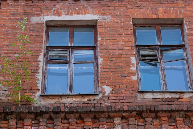 Vieilles fenêtres dans une maison en brique avec un reflet du ciel Contexte architectural