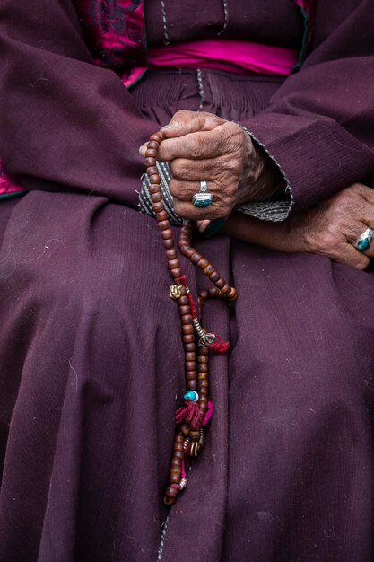 Les vieilles mains d'une femme tibétaine tenant des perles de prière bouddhistes dans un monastère de Hemis dans le district de Leh, dans le Ladakh, dans le Jammu et le Cachemire, dans le nord de l'Inde.