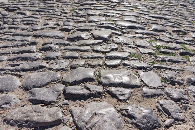 Vieilles pierres inégales sur une route pavée