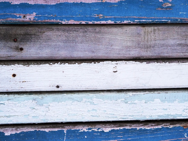 Les vieilles planches sont peintes avec différentes couleurs de bleu, blanc, la peinture se décolle