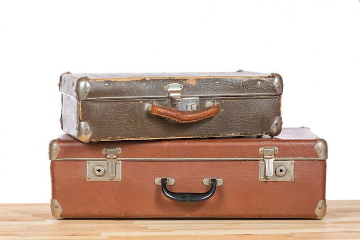 Photo vieilles valises vintage sur une table en bois clair isolée