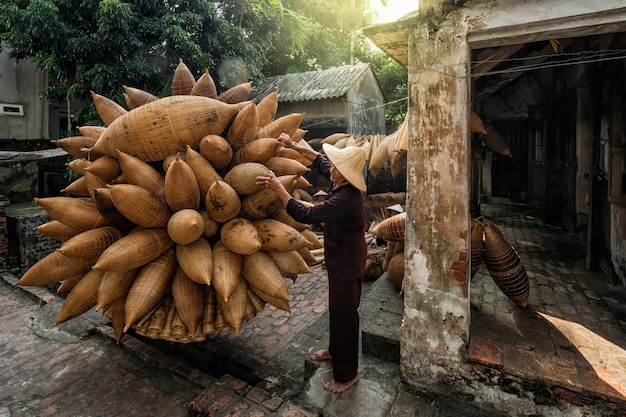 Vieux artisan mâle vietnamien debout avec vélo