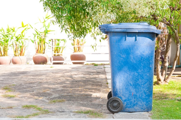 Photo vieux bac bleu sale avec roue dans le parc