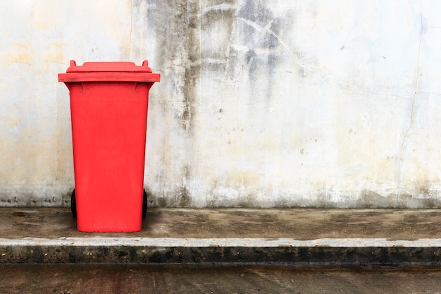 Vieux bac en plastique rouge avec fond de mur de brique