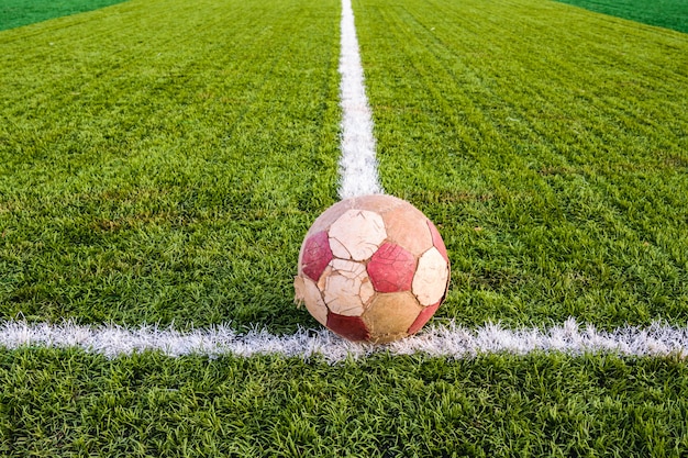 Vieux ballon de football sur l'herbe