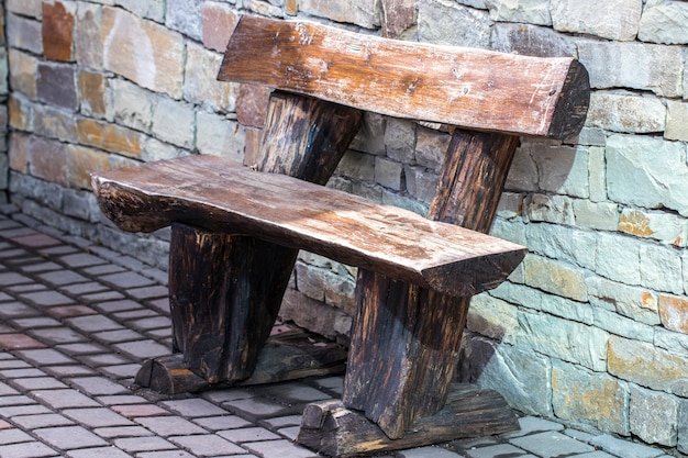 Photo vieux banc en bois près du mur de pierre