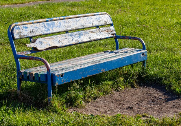 Un vieux banc avec de la peinture dépouillée dans le parc