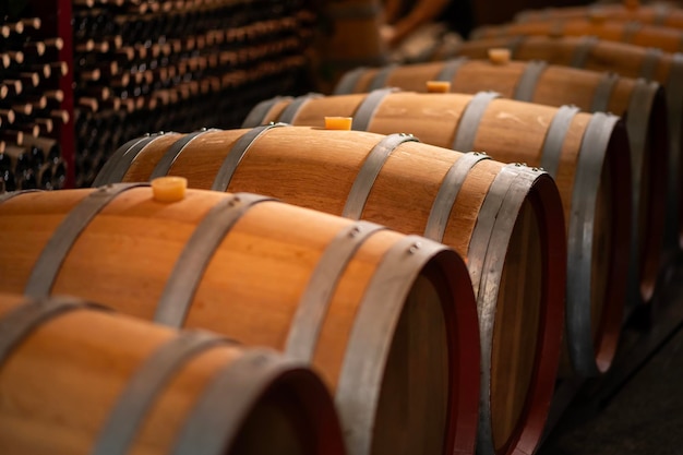 De vieux barils de vin en bois empilés dans une cave dans l'ordre