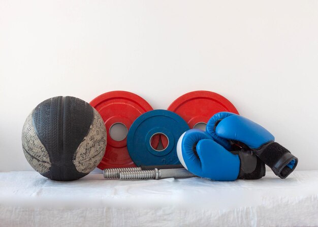 Vieux basket-ball d'haltères en rouge et bleu et équipement de sport de gants de boxe.