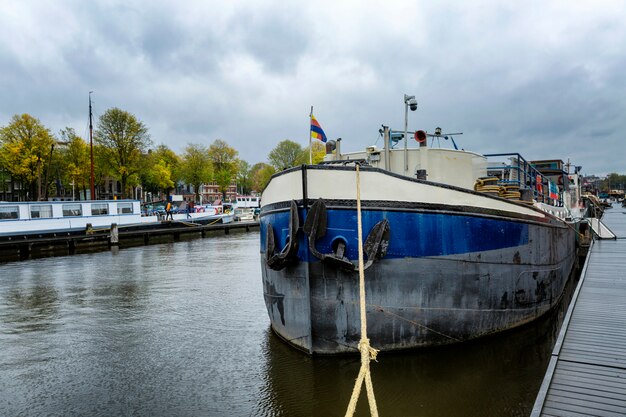 Vieux bateau amarré au quai. Un hôtel sur l'eau traditionnel à Amsterdam.