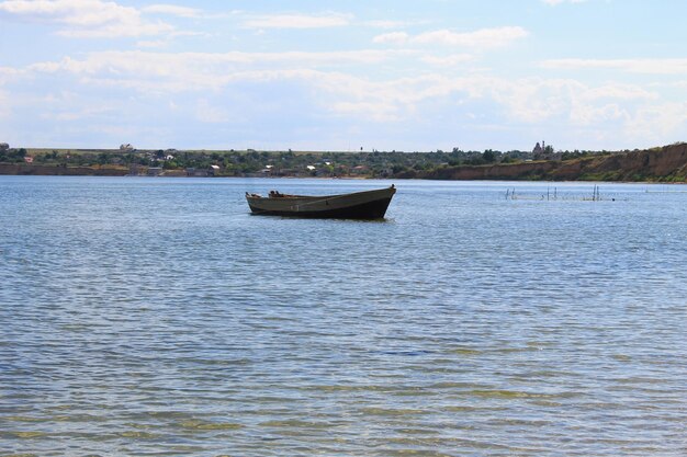 Vieux bateau de pêche à l'ancre en mer près du rivage de sable
