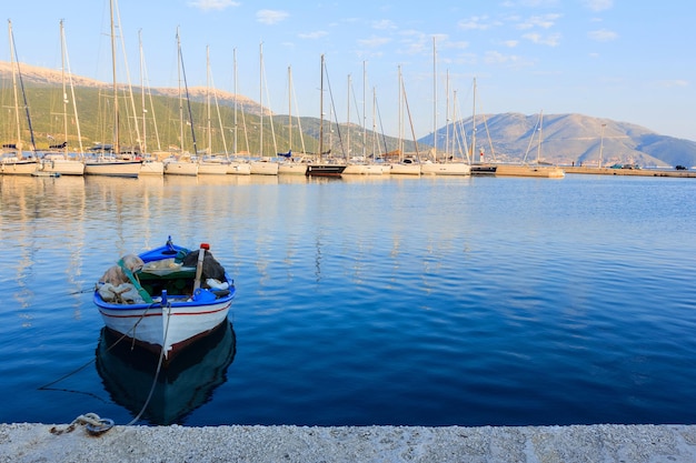 Vieux bateau de pêcheur avec des yachts modernes à quai