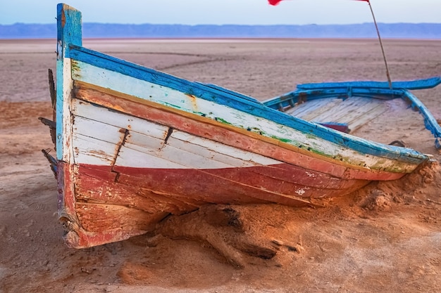 Un vieux bateau se tient seul au milieu d'un désert de sel