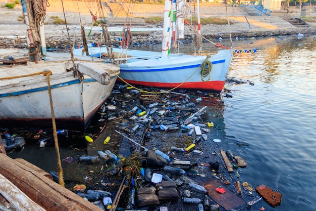 Vieux bateaux amarrés dans le port sale. Pollution de la rivière, de la mer, de l'eau de mer avec des déchets, des déchets plastiques. Concept de pollution du littoral océanique, maritime et fluvial avec des déchets en plastique