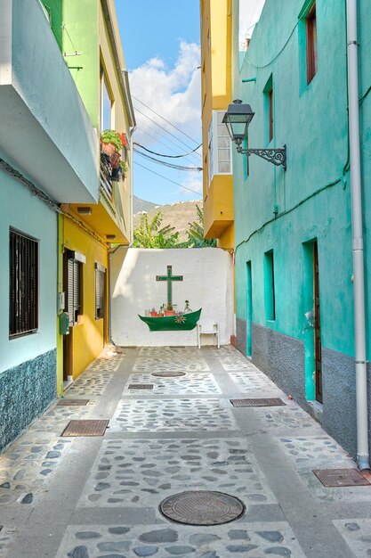 Vieux bâtiments colorés avec un mur avec une croix ou un crucifix dans la ville de Santa Cruz de La Palma Maisons lumineuses et dynamiques ou maisons construites par l'architecture traditionnelle le matin dans un village