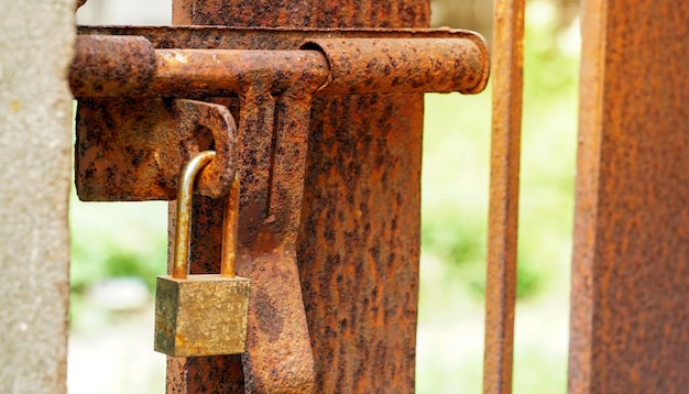 Vieux cadenas sur la porte en fer rouillé Vieille porte en acier de serrure à clé rouillée Vieille porte verrouillée