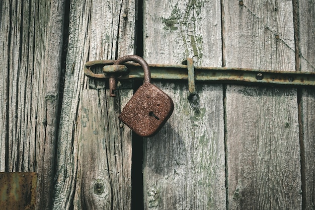 Vieux cadenas rouillé sur porte en bois. ouvrir la serrure vintage. concept de protection de sécurité. Cadenas ouvert