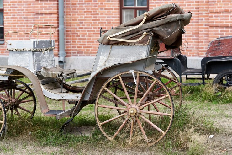 Photo vieux chariot blanc sur le fond d'un bâtiment en brique rouge. chariot vintage blanc